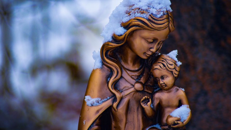 brown mother and child statue partially covered with snow