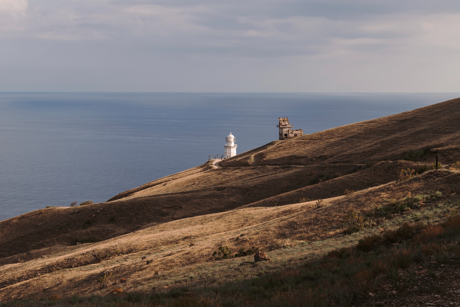 a lighthouse on a hill overlooking the ocean