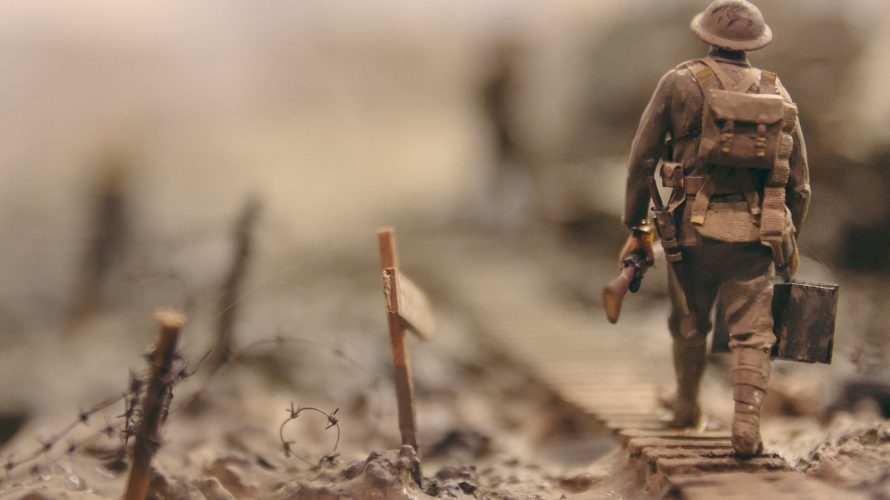 soldier walking on wooden pathway surrounded with barbwire selective focus photography